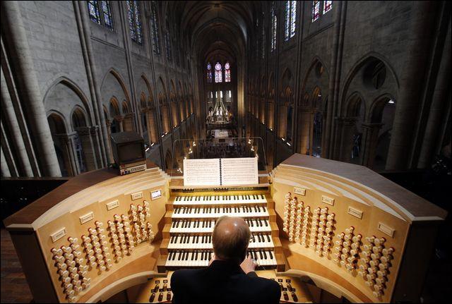 In this Thursday, May 2, 2013 file photo, Philippe Lefebvre, 64, plays the organ at Notre Dame cathedral in Paris. Pipe by precious pipe, the organ that once thundered through fire-ravaged Notre Dame Cathedral is being taken apart. The mammoth task of dismantling, cleaning and re-assembling France's largest musical instrument started Monday Aug.3, 2020 and is expected to last nearly four years.