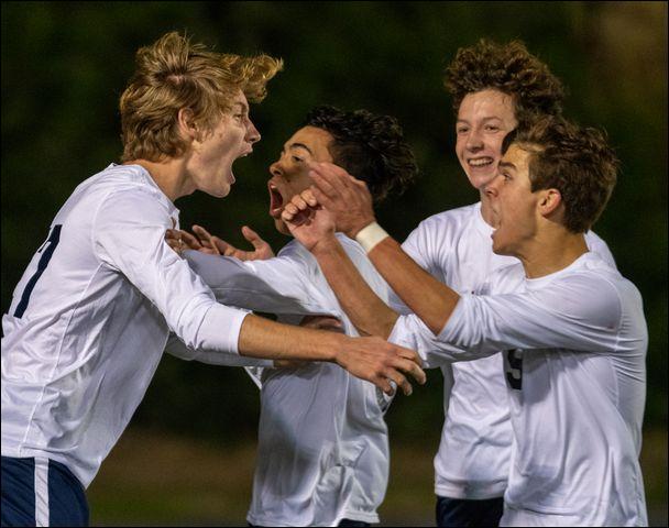 Dane Beller, left, celebrates one of his two goals with teaqmmates Friday night as the Mars boys complered a perfect season with a 2-1 victory over Northern York in the PIAA Class 3A soccer championship game at Hersheypark Stasium.