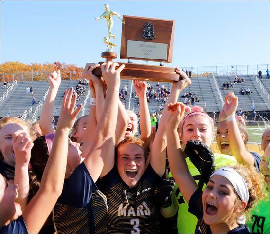 Mars Ellie Coffield (3) raises the WPIAL trophy surrounded by her teammates following the Planets' WPIAL Class 3A championship win. Mars went on to win the PIAA championship as well, capping an undefeated season. The Mars boys were also undefeated and state champions. The two teams' epic campaigns earned them the Butler Eagle's top sports story of 2020.