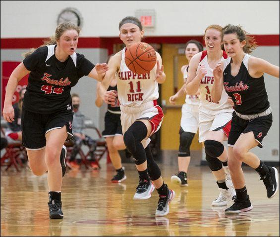 After taking possession, Slippery Rock's Kelly Benson (11) rushes down the court, Franklin defenders Lauren Billingsley (44) and Gabby Lajuenesse during the Rockets' 54-18 victory.