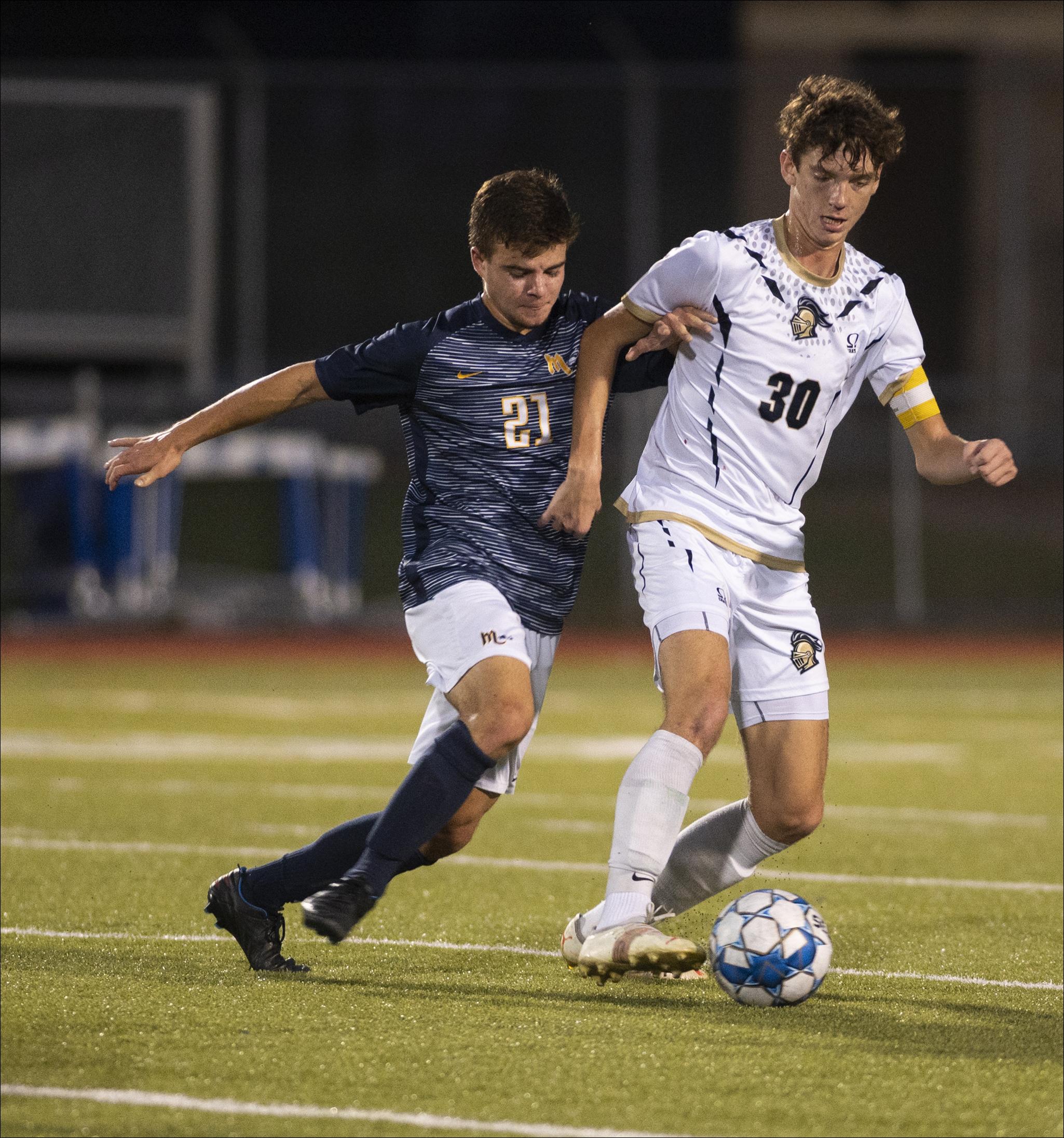Knoch's Jared Cushey (30) tries fending off pressure from Mars' Devin Schupt during the Planets' 2-1 boys soccer win in double overtime Monday night at the Mars Athletic Complex.