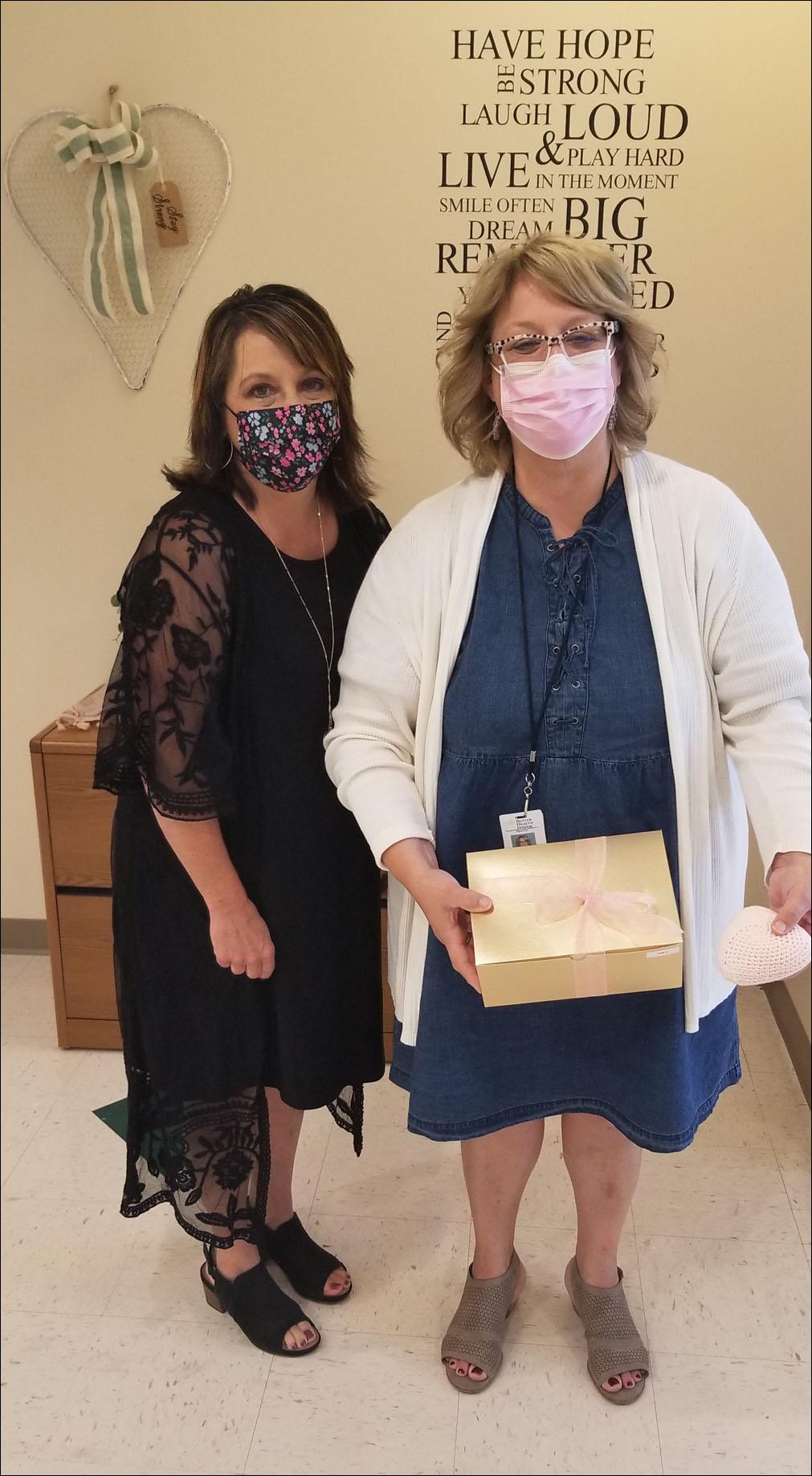 Kris Bowser, development and events manager at Butler Health System and Stacy Meyer, oncology patient manager at the health system, pose with a knitted knocker and the decorative box they come in. The knitted knockers are used to resemble the presence of a breast for women who have undergone a mastectomy due to breast cancer.