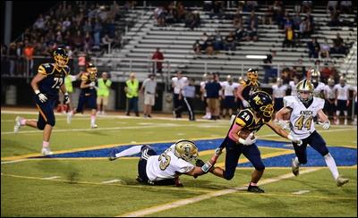 Knoch's Exzavier Johnson (23) is dragged by Mars' Finn Seideneck during a game at Mars Athletic Complex on Friday. The Planets won 14-13.
