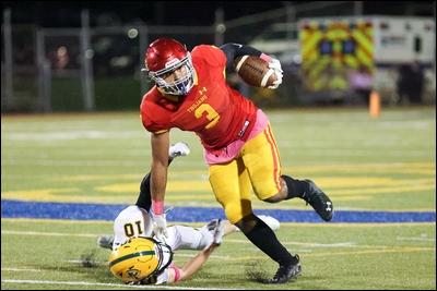 North Catholic running back Kyle Tipinski runs over a Deer Lakes defender at the Mars Athletic Complex.
