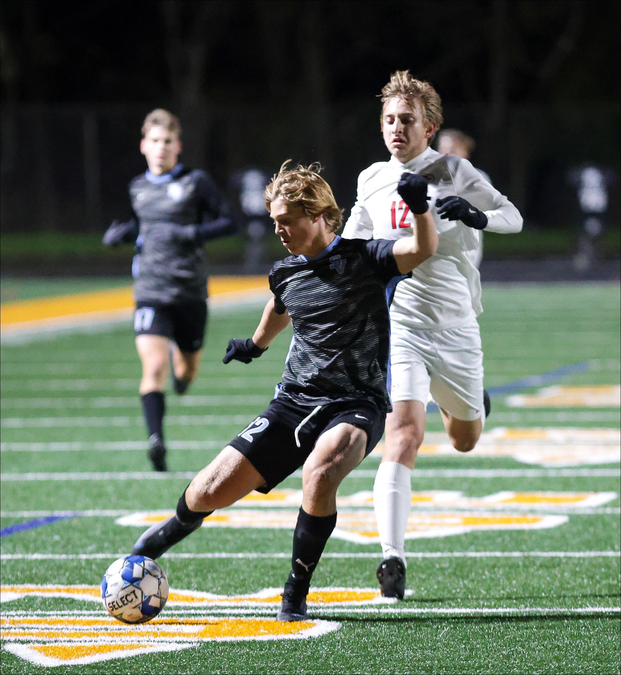 Seneca Valley midfielder Cole Kamerac gets off a shot in front of Fox Chapel defender Quentin Cook in WPIAL Class 4A boys soccer semi-final action at North Allegheny's Newman Stadium Tuesday night. The Raiders won the game, 1-0.
Nate Black/Special to the Eagle