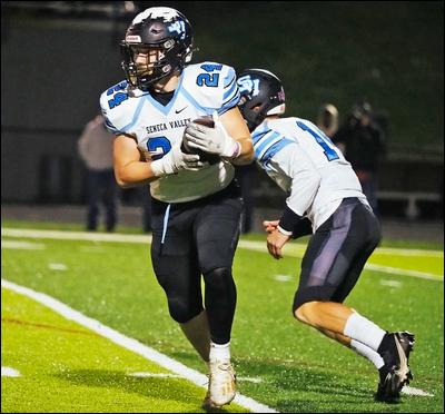 Seneca Valley running back Nolan Dworek, 24, receives a hand off from quarterback Sean O'Shea, 14, during a game against Central Catholic on Friday, November 12, 2021.